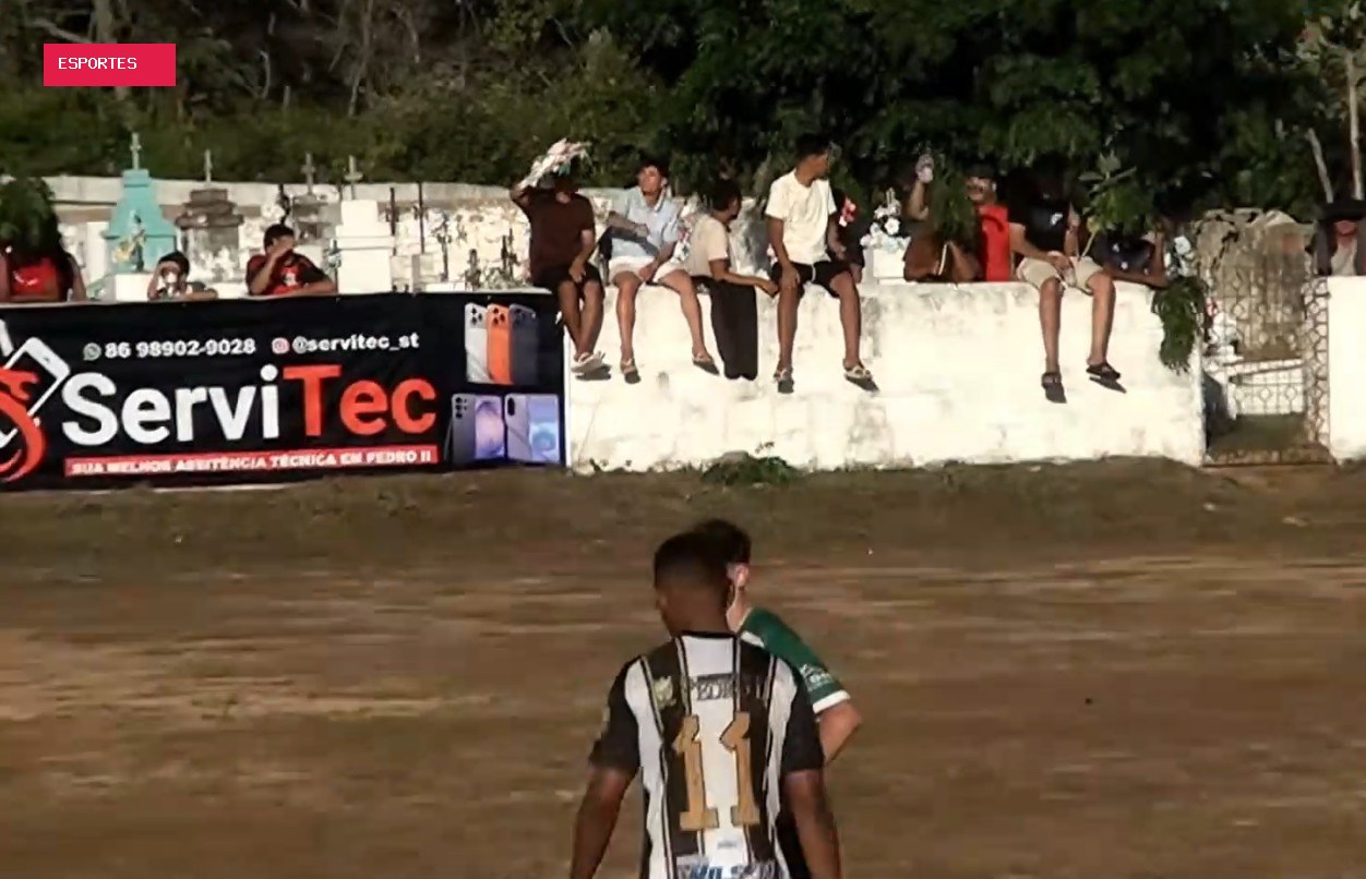 Torcedor usa coroa de flores para fugir do sol em jogo amador ao lado do cemitério no Piauí