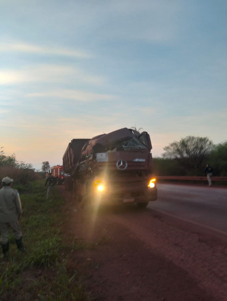 Carreta avariada parada no acostamento da BR-262 ao amanhecer, com viatura dos bombeiros ao fundo
