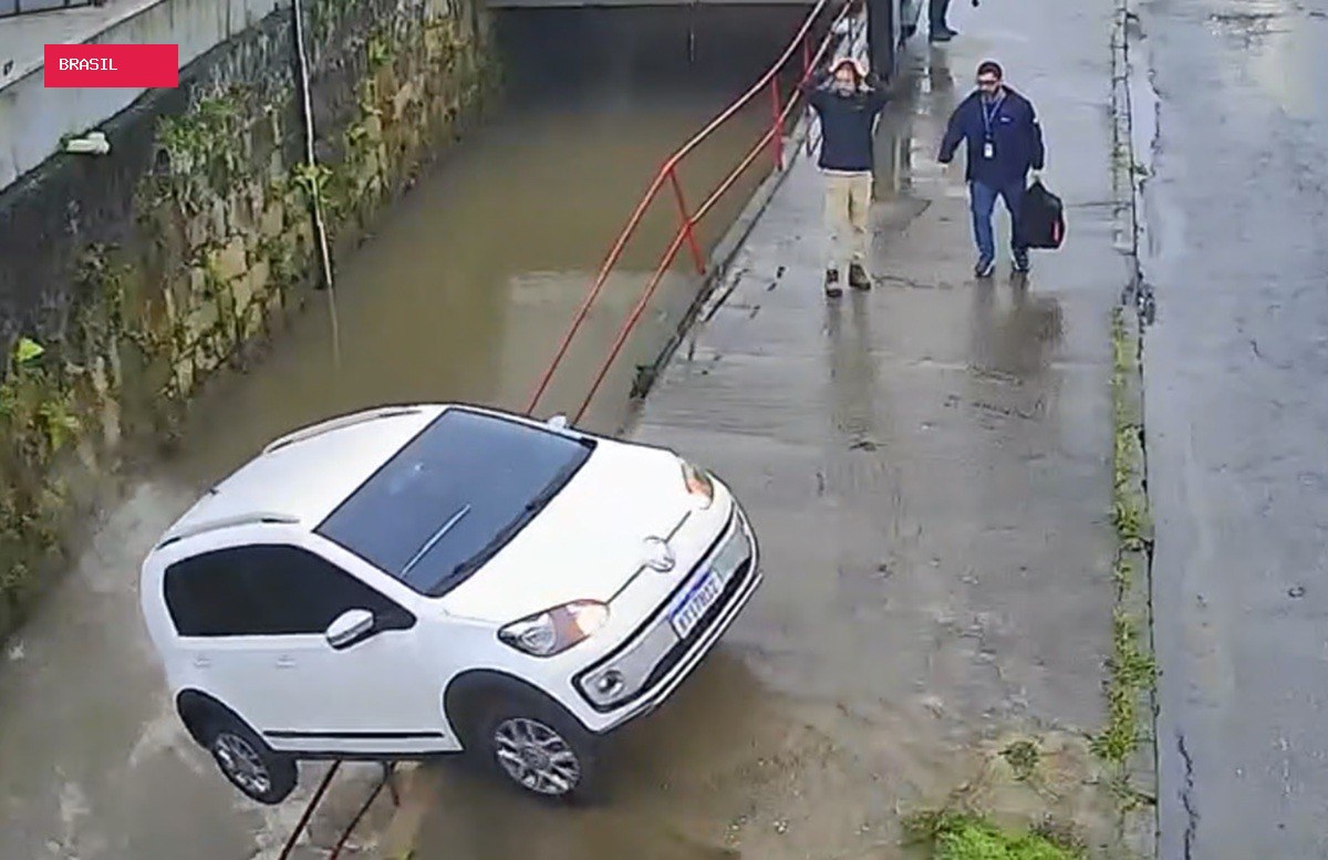 Carro sem motorista atravessa rua e cai em rio em Petrópolis; vídeo mostra reação de homem que leva as mãos